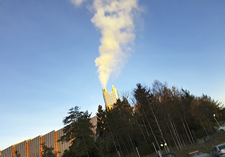 Varmepumpen tar ut ekstra varme av røykgassen ved å kondensere vanndampen i røykgassen. Dette bildet viser at røykgassen ut av skorsteinen er så å si uten vanndamp (høyre pipeløp).