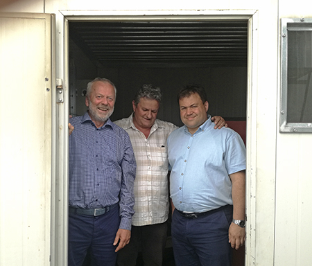 Entreprenør Sandor Bartha ( i midten) eier og driver flere containerbaserte bioenergianlegg i Transylvania. Her viser han stolt frem ett av disse anleggene til Hans Borchsenius (tv) og Sergei Faschevsky (th) i Norsk Energi. 